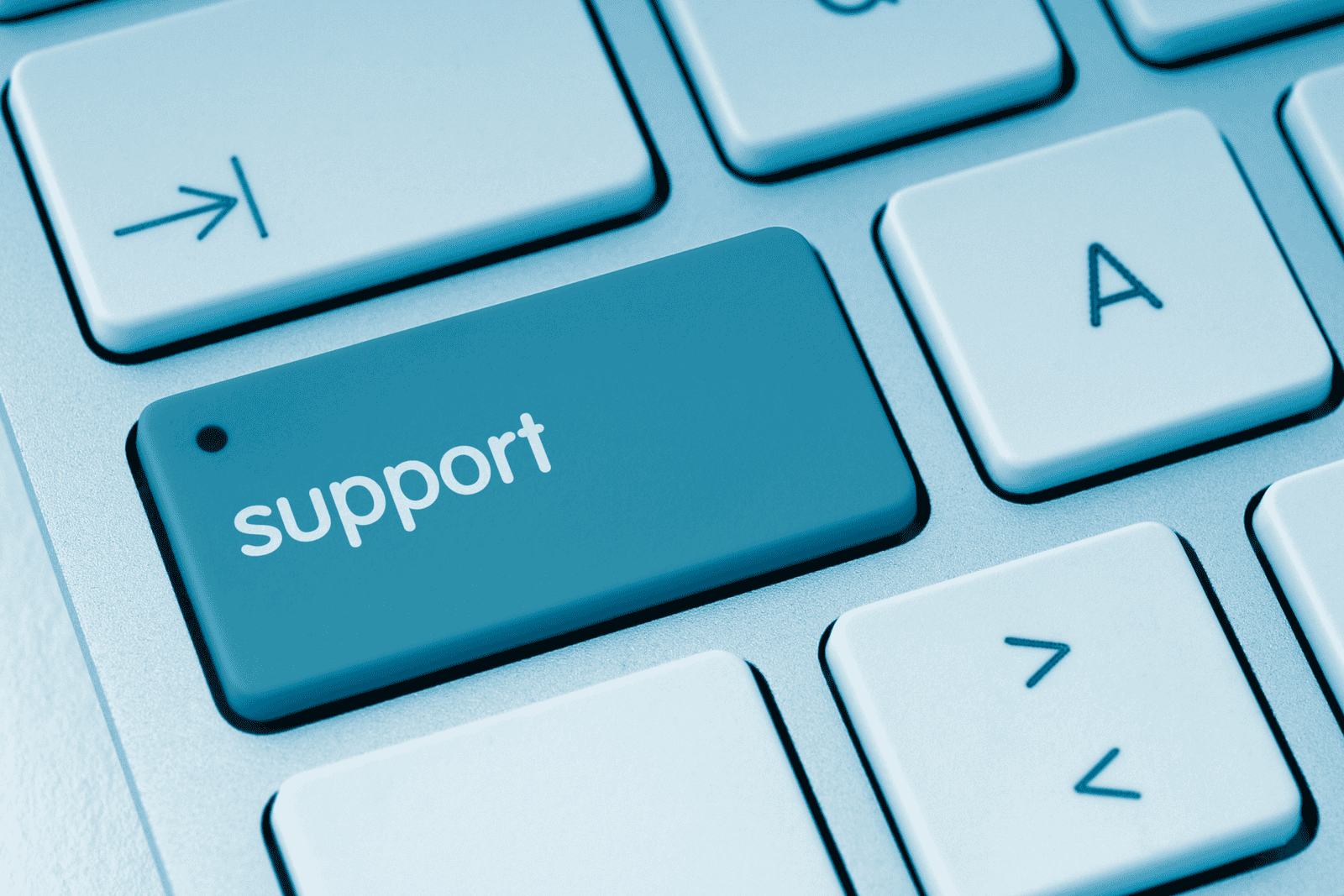 Close-up of a computer keyboard with a highlighted blue key labelled “support”, symbolising technical assistance or help services.