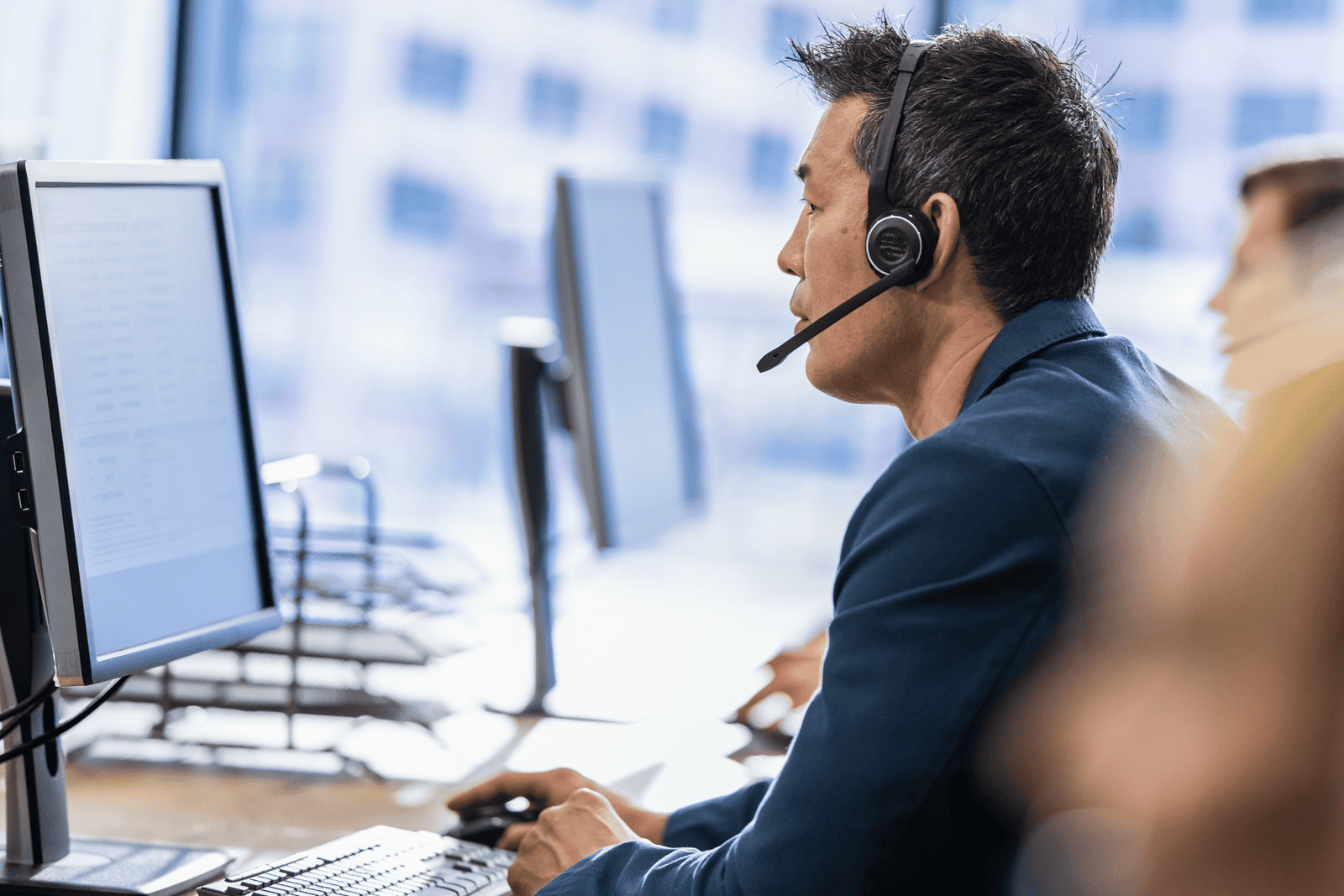 Someone sat at their desk with a headset phone on discussing mobile management with