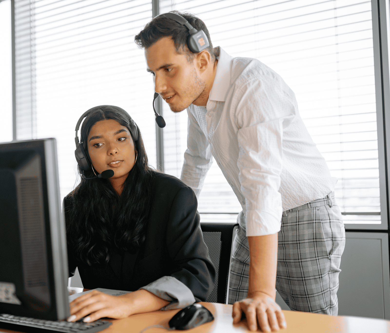 IT support team members wearing headsets collaborating at a workstation, providing proactive technical support and ensuring reliable business system performance.